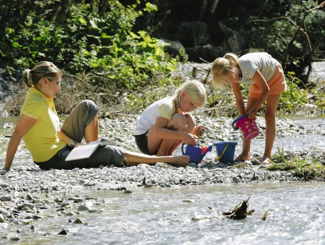 Kinder spielen am Bach